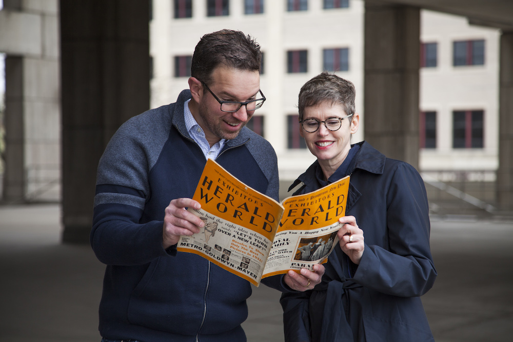 Eric Hoyt and Kelley Conway looking at an issue of Exhibitors Herald World.